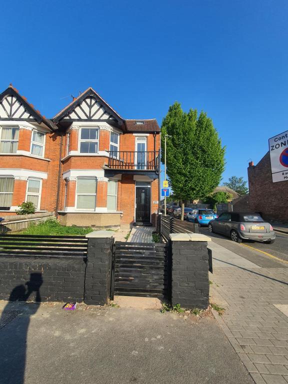 un gatto è in piedi di fronte a una casa di mattoni di Marble House a Edgware