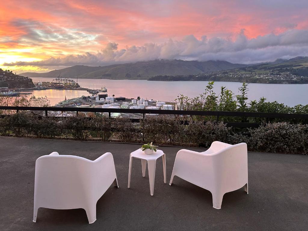 two chairs and a table with a view of the water at Sanctuary By The Sea in Christchurch