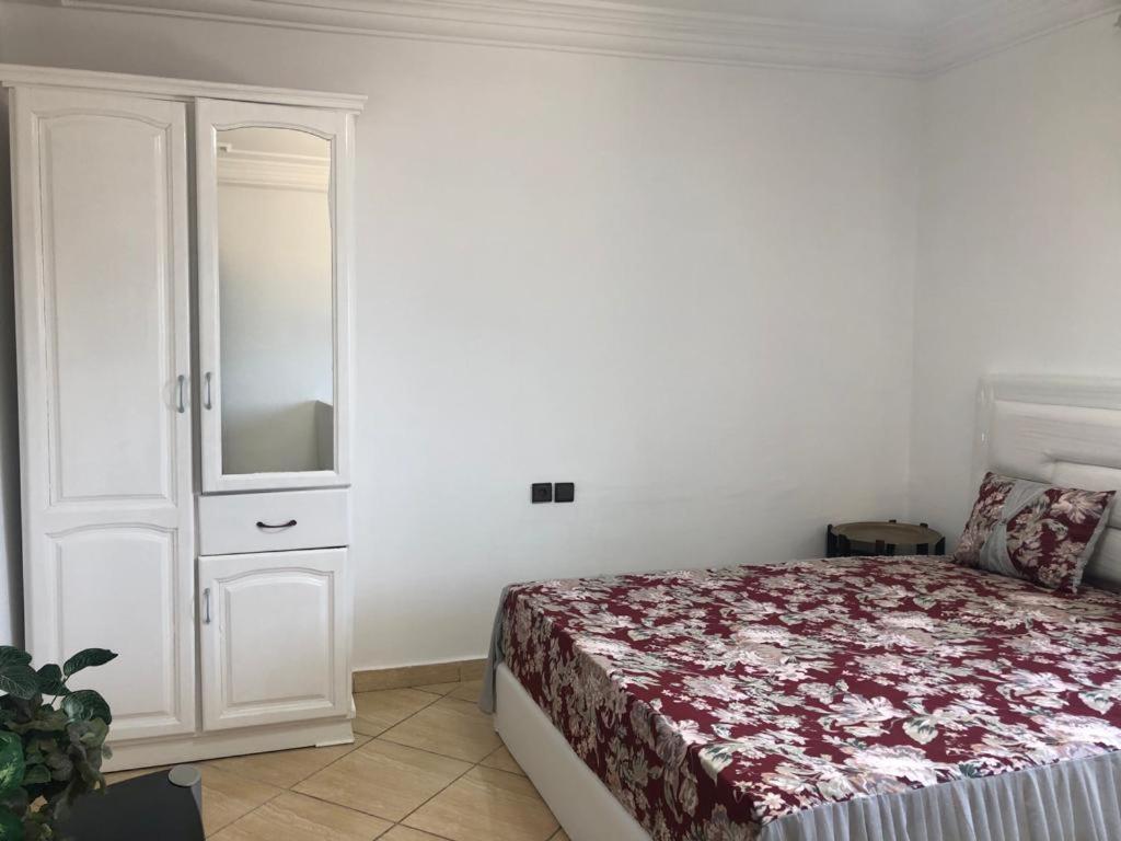 a bedroom with a bed and a dresser in it at Grand appart avec vue sur mer in Oued Laou