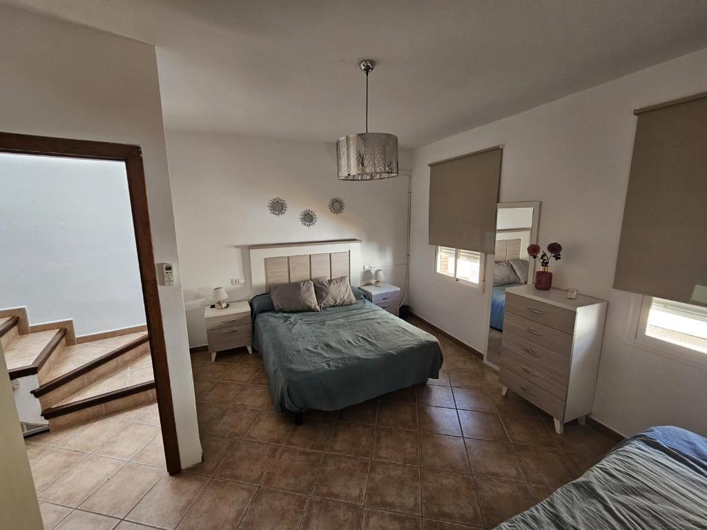 - une chambre avec un lit, une commode et un miroir dans l'établissement Casa el albaicin, à Alhaurín el Grande