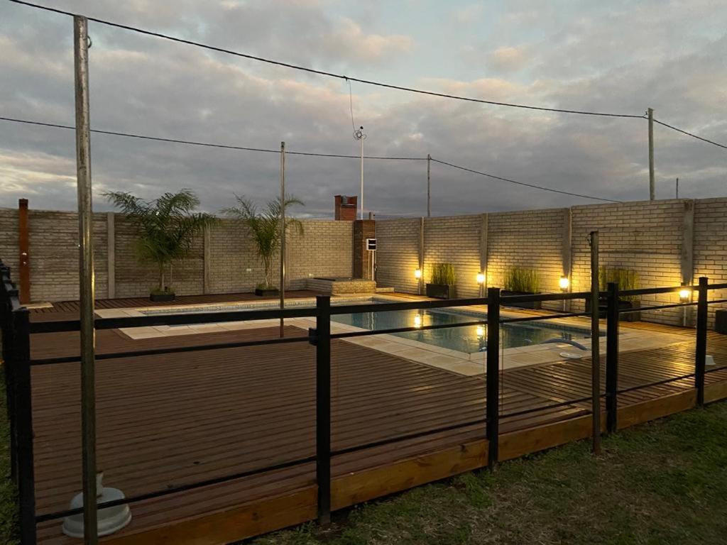 パラナにあるQuinta Los Pinos Paranáの木製デッキとフェンス付きのスイミングプール