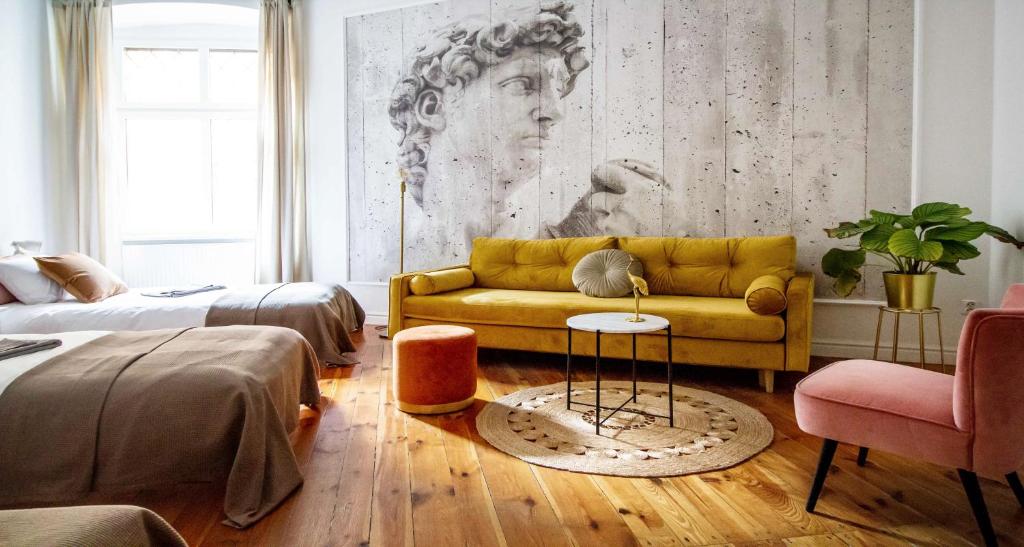 - un salon avec un canapé jaune et un lit dans l'établissement Old Town Centrum Residence Apartments, à Poznań