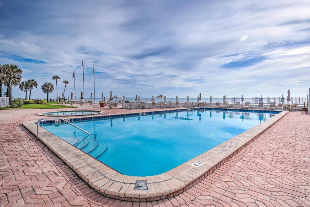 a large pool with blue water on a brick road at Ocean Jewels Resort Studio with Community Perks! in Daytona Beach