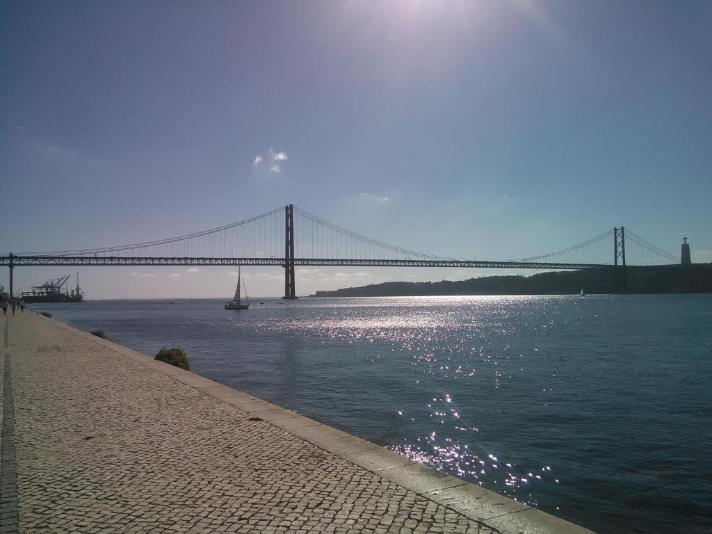 uma ponte sobre um rio com um barco na água em Caparica Holidays em Charneca