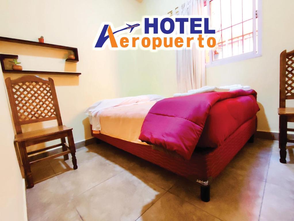 a bed in a room with a hotel aeropolis sign on the wall at Hotel AEROPUERTO Jujuy in Perico