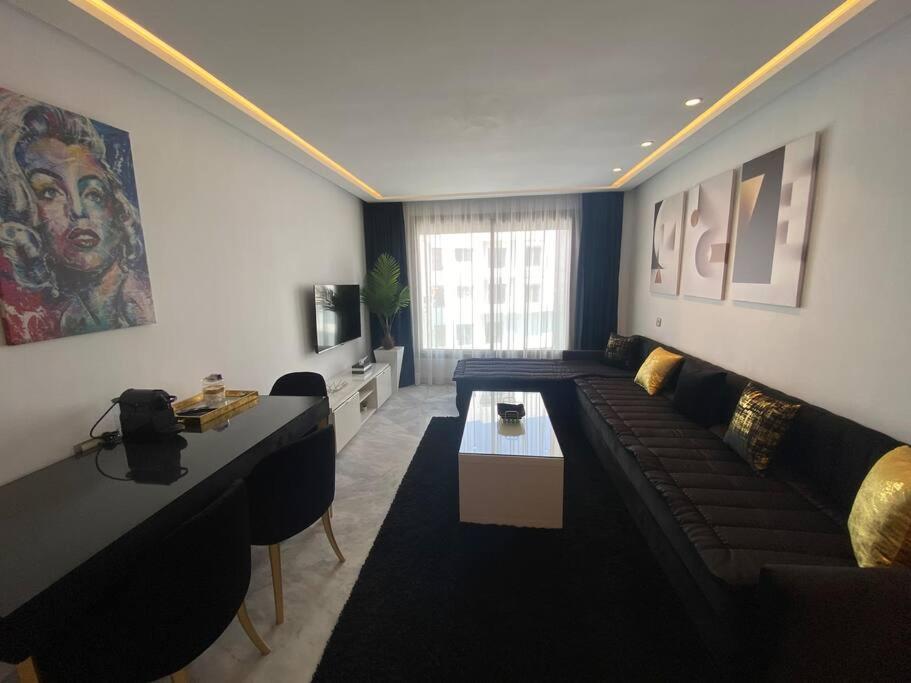 uma sala de estar com um sofá e uma mesa em Corniche Casablanca - Black New em Casablanca