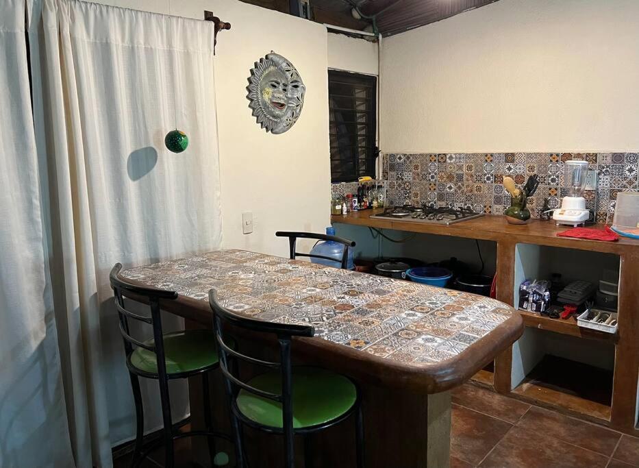 a kitchen with a table with chairs and a counter top at Bungalow La Media Luna Brisas de Zicatela in Brisas de Zicatela
