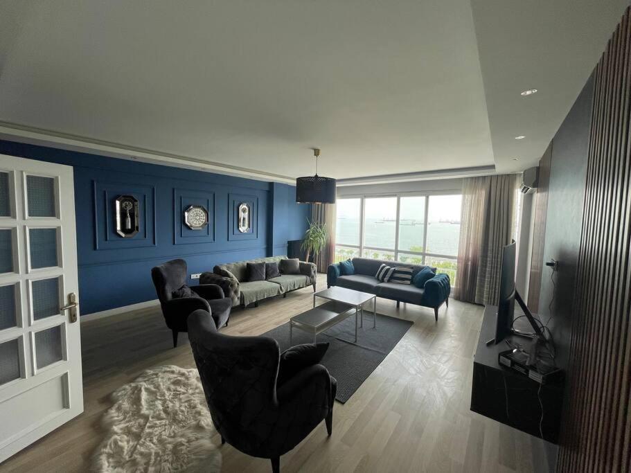 sala de estar con paredes azules, sofá y sillas en Mükemmel Deniz Manzaralı Lüks, en Estambul