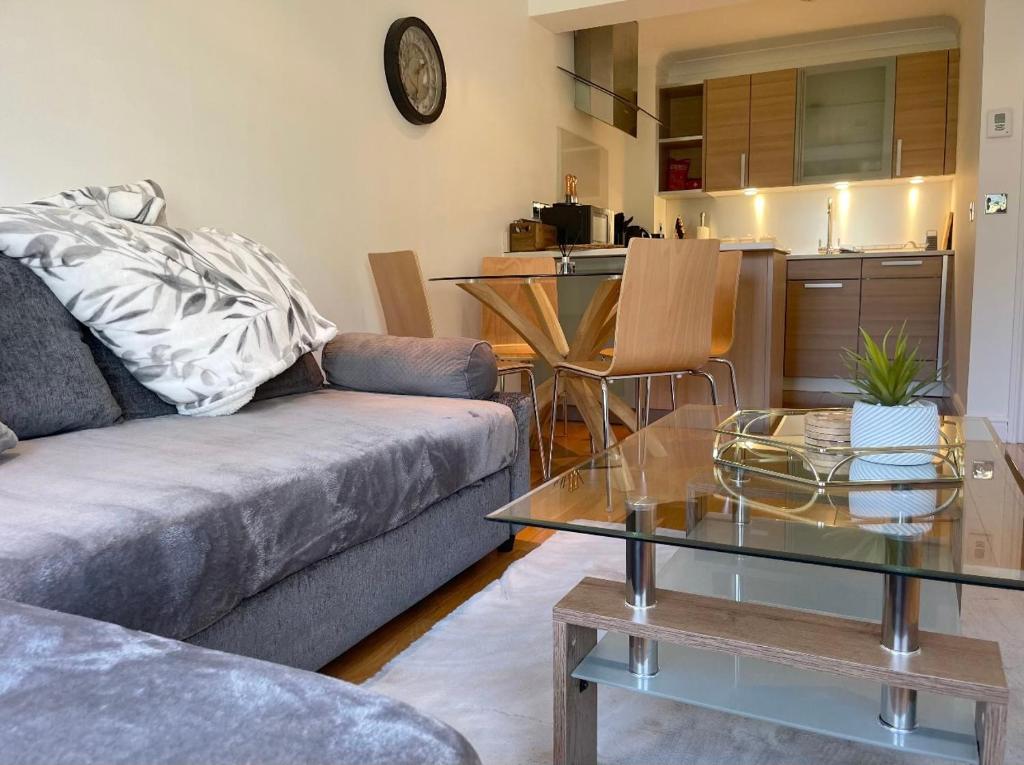 uma sala de estar com um sofá e uma mesa em WATCH CHANGING OF THE GUARD AND WALK TO THE CASTLE! 2 Bedroom Apartment em Windsor
