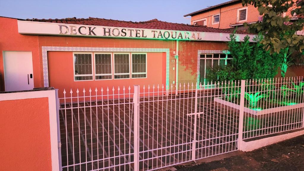 uma cerca em frente a um canil de um hospital de cães em Deck Hostel Taquaral em Campinas