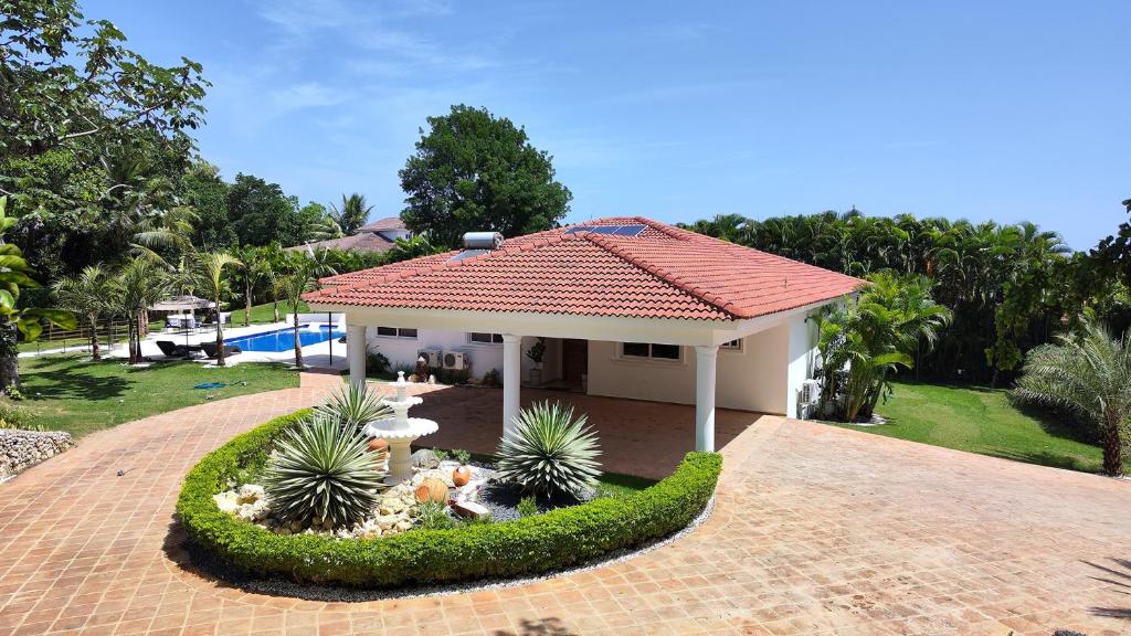een klein huis met een tuin ervoor bij Luxury 4-Bedroom Villa with Heated Pool in Residencial Casa Linda in Sosúa