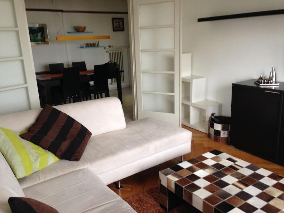 una sala de estar con 2 sofás blancos y una mesa. en Appartement de 3 chambres à coucher, en Lausana