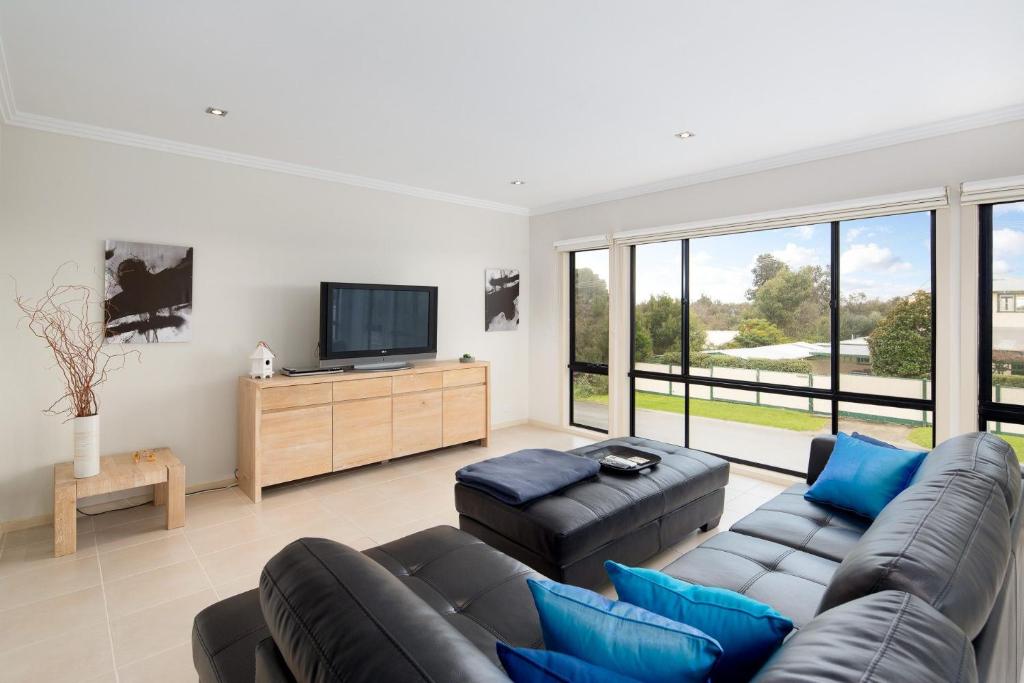 Una sala de estar con un sofá y un televisor de pantalla plana. en Beachside Retreat Cowes, en Cowes