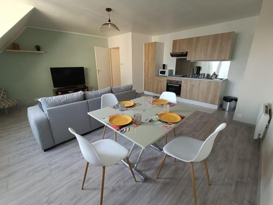 a living room with a table and white chairs at Magnifique F2 Cosy Centre-Ville in Lisieux