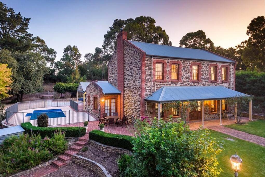 a brick house with a pool and a yard at Hahndorf Luxury Retreat in Hahndorf