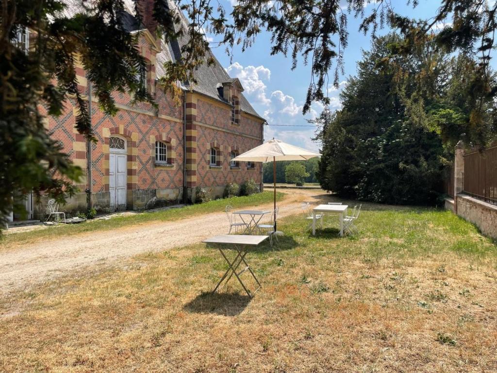 einem Picknicktisch und einem Regenschirm vor einem Gebäude in der Unterkunft Appartement Trévol, 5 pièces, 8 personnes - FR-1-489-215 in Trévol