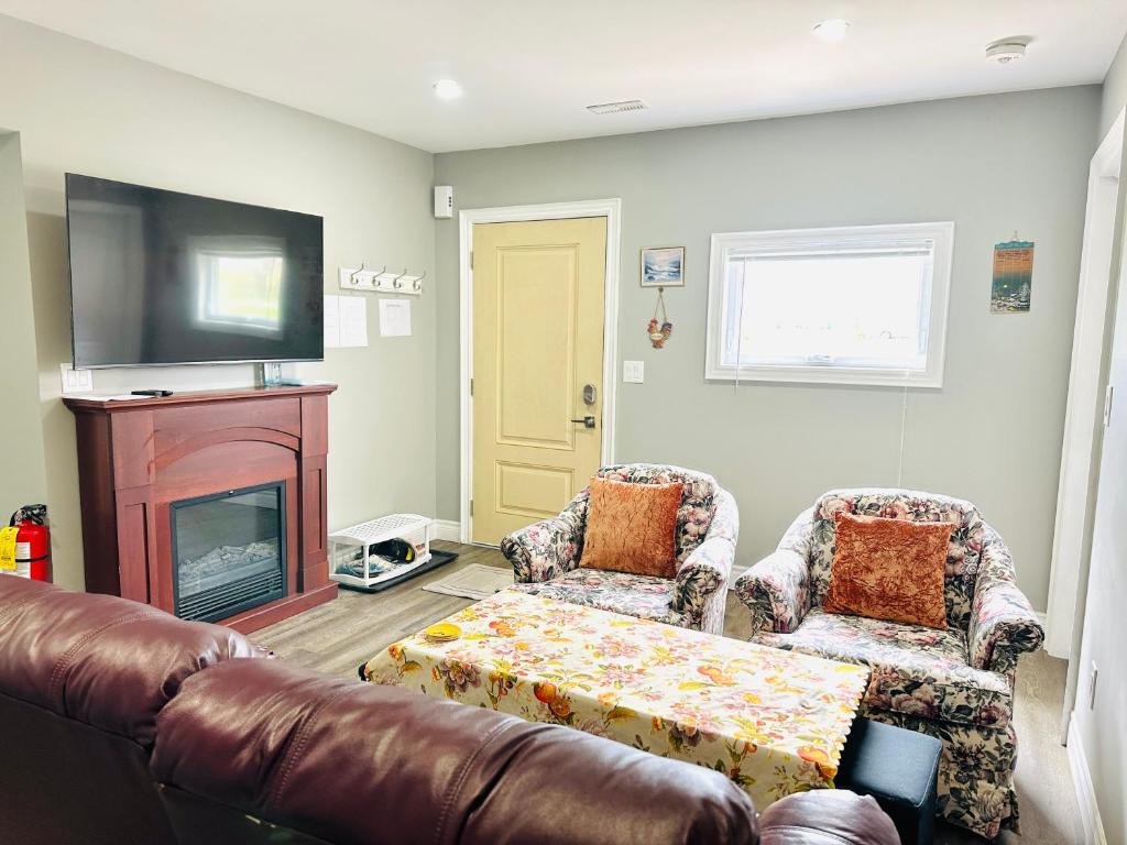 een woonkamer met een bank en een open haard bij Cozy 3-bedroom farmhouse in wine-country in Niagara on the Lake
