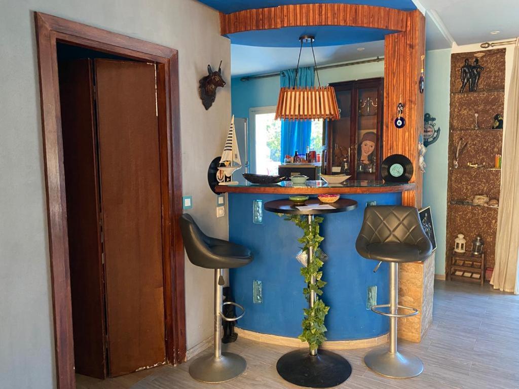 Cette chambre bleue dispose d'un bar avec deux tabourets. dans l'établissement Maison du bonheur, à Harhoura