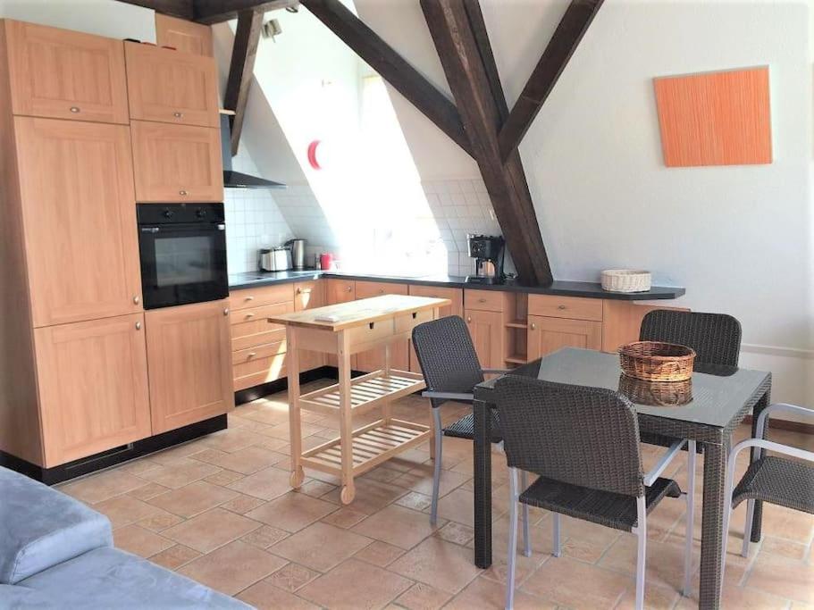 una cucina con armadi in legno, tavolo e sedie di Beautiful Top Floor Apartment with Lake View a Losanna