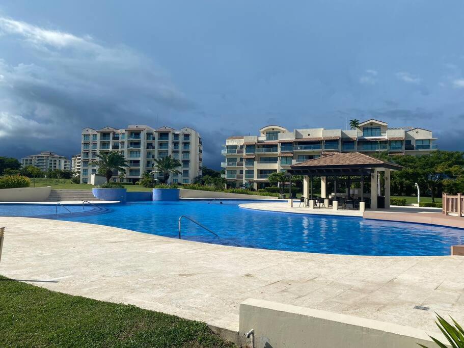 una gran piscina con cenador y edificios en Lujoso y Familiar Apartamento de Playa y Golf en San Carlos Panamá, en San Carlos