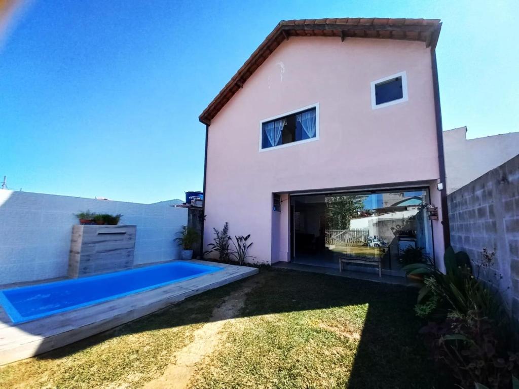 a house with a swimming pool in front of it at Chalé Penedo Charmosa in Penedo