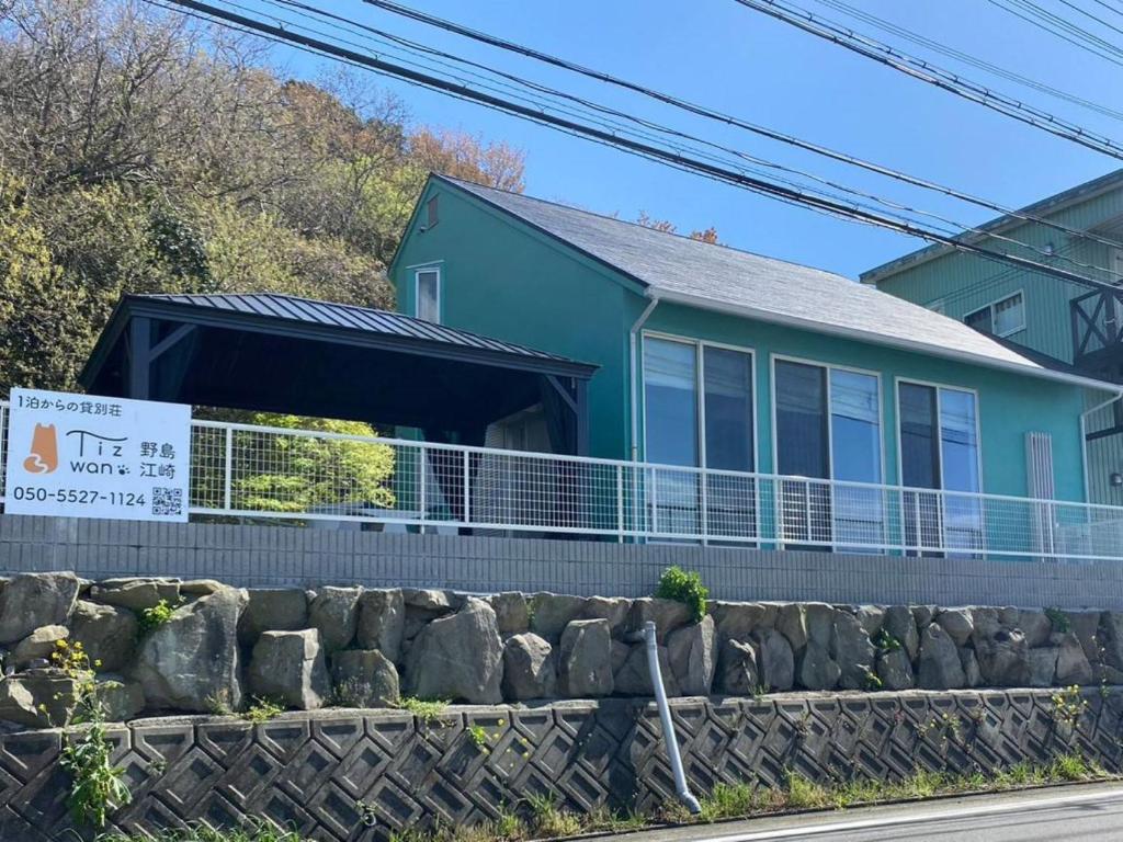 een blauw huis met een bord ervoor bij Tiz wan 野島江崎 in Awaji