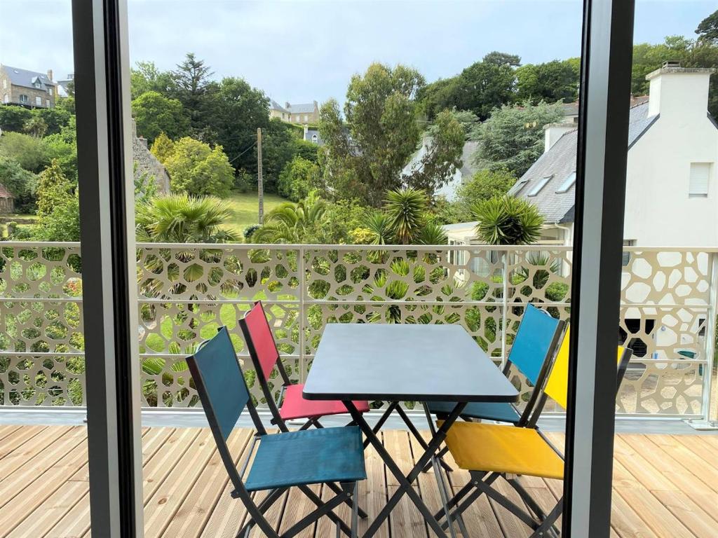 a table and chairs on a balcony with a view at Appartement neuf avec balcon, proche du port de Perros-Guirec - FR-1-368-392 in Perros-Guirec