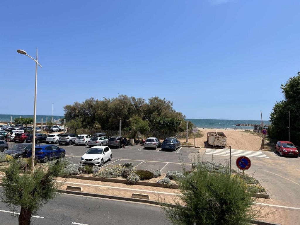 ein Parkplatz mit Autos vor dem Meer in der Unterkunft Appartement Valras-Plage, 2 pièces, 4 personnes - FR-1-701-66 in Valras-Plage