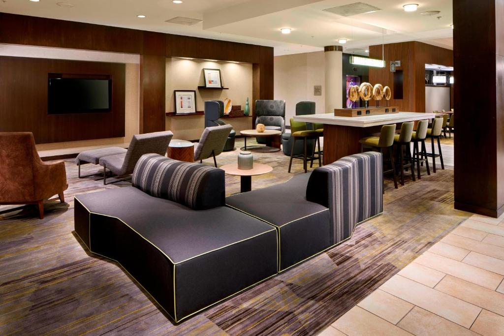 a lobby with a couch and chairs and a bar at Courtyard by Marriott San Antonio Six Flags at The RIM in San Antonio