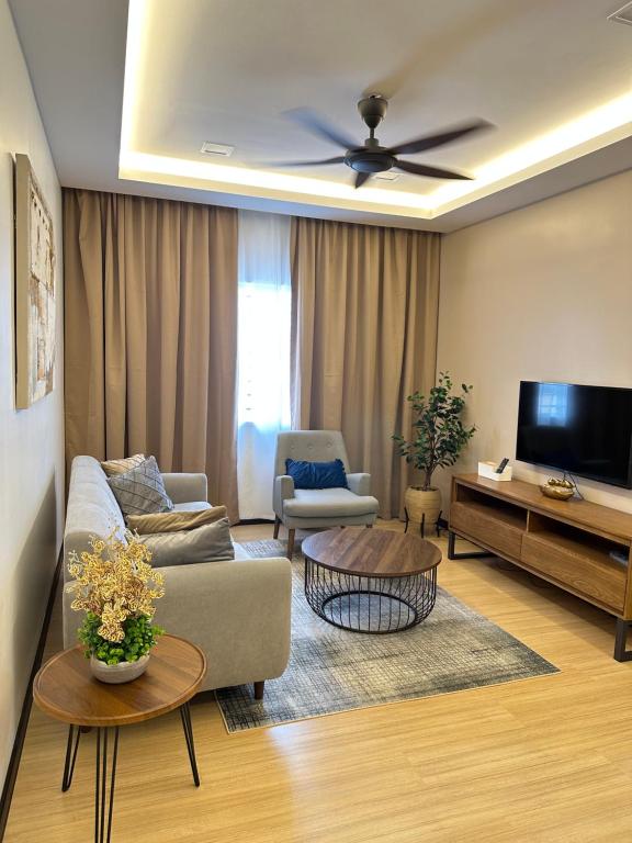 a living room with a couch and a tv at Modern Stylish Apartment (Seaview) near KTCC Mall. in Kuala Terengganu