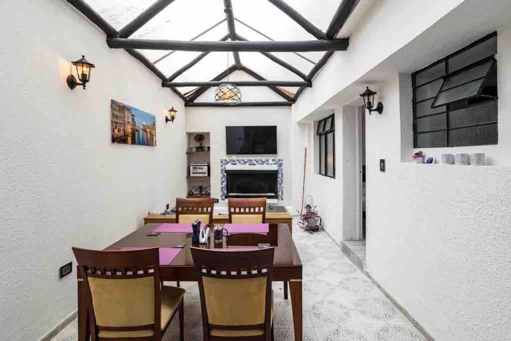 ボゴタにあるGran apartamento en la Candelaria centroの長いテーブルと椅子のあるダイニングルーム