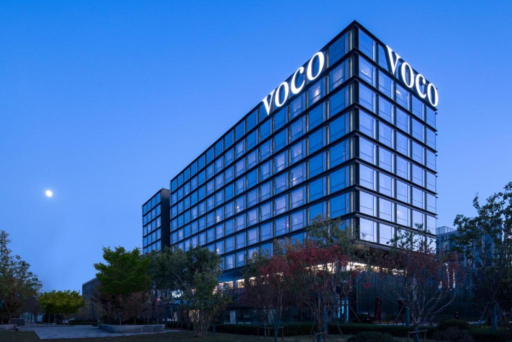 a building with a sign on top of it at voco Hefei Binhu, an IHG Hotel in Hefei