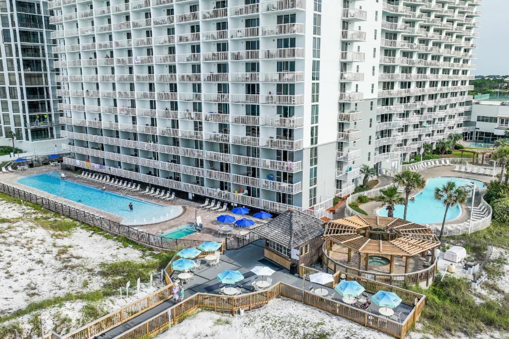 an aerial view of a resort with a pool and a building at Pelican Beach Resort Condos in Destin