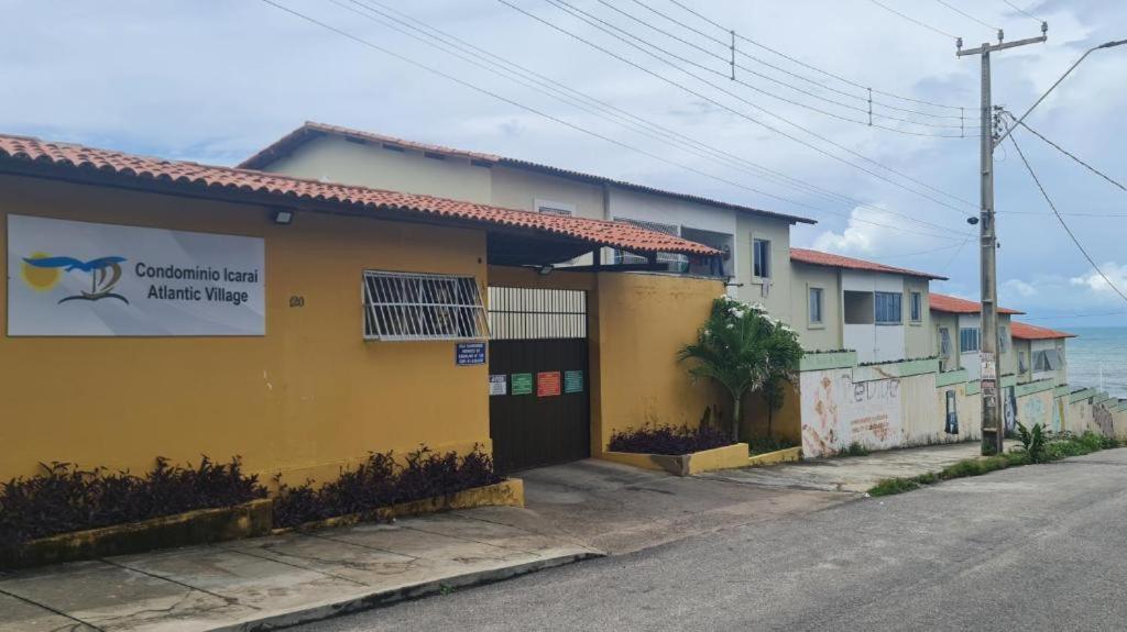 un edificio amarillo al lado de una calle en Icaraí Atlantic Village, en Caucaia