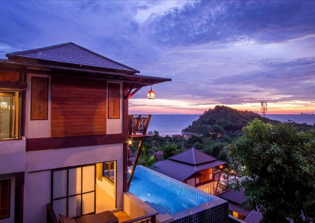 una casa con vistas al océano al atardecer en Puteri Lanta Family Villas en Ko Lanta