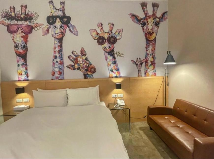 a bedroom with a bed and some giraffe heads on the wall at Travel Art Inn in Chiayi City