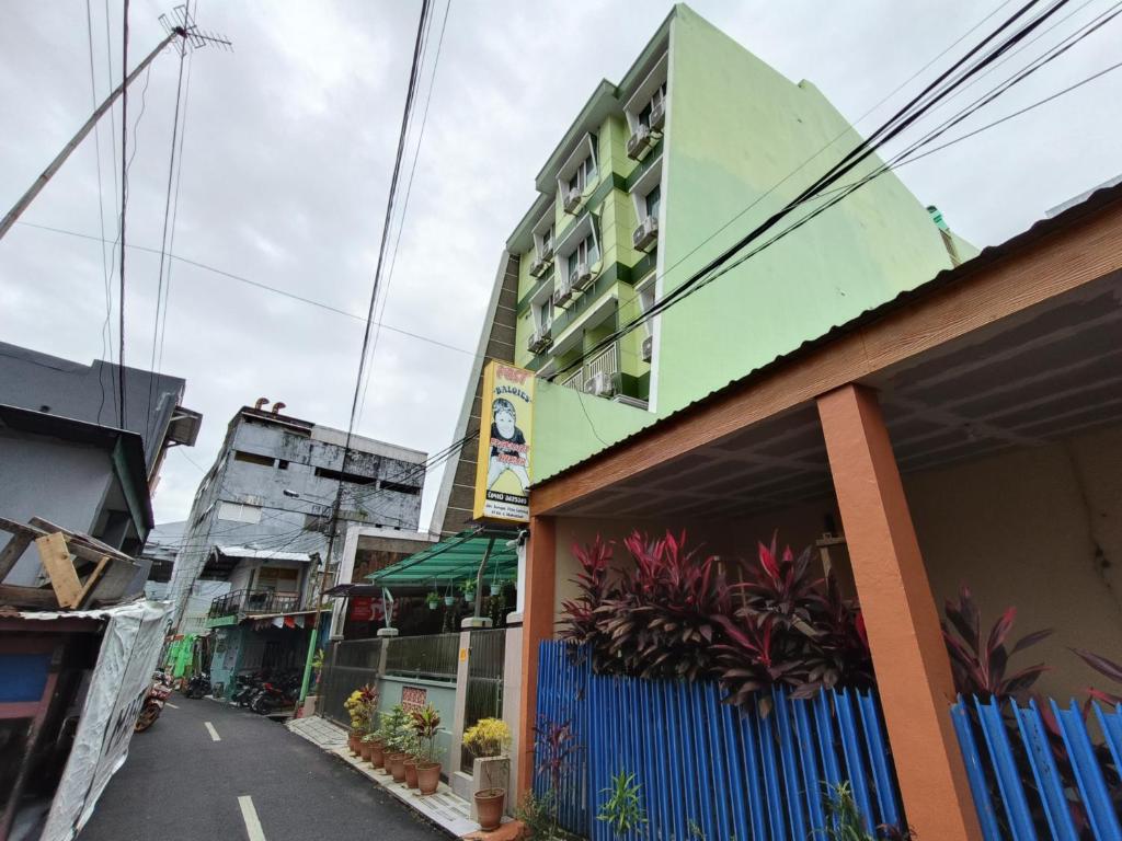 a building with a blue fence in front of a building at Balqies Homestay Syariah Makassar Mitra RedDoorz in Makassar