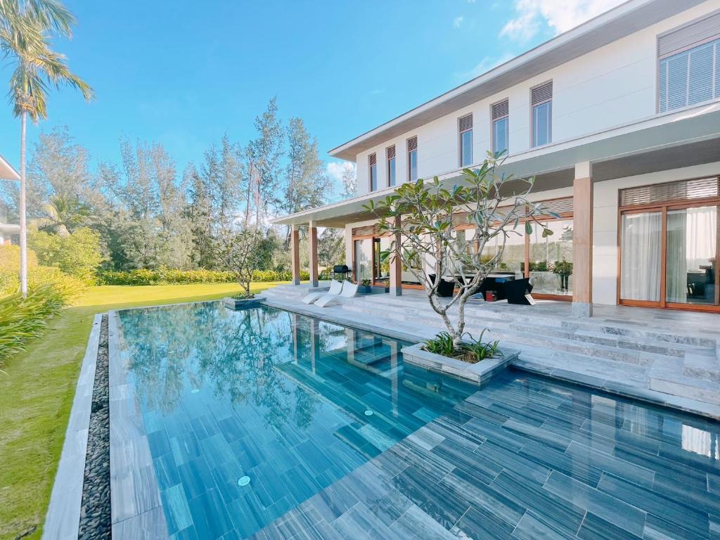 an image of a swimming pool in front of a house at Memories Holiday beach villa Da Nang in Da Nang