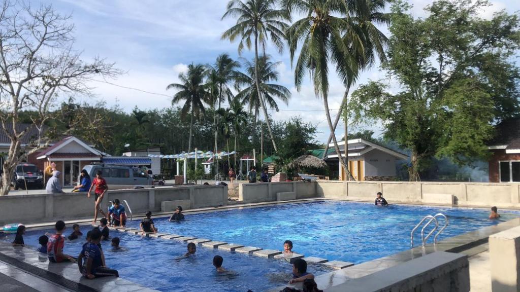 um grupo de pessoas sentadas numa piscina em Family Room HAMSHA VILLAGE 