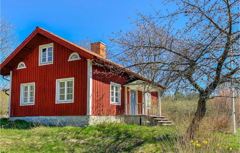 una casa roja sentada en la cima de una colina en Nice Home In Valdemarsvik With Kitchen, en Valdemarsvik