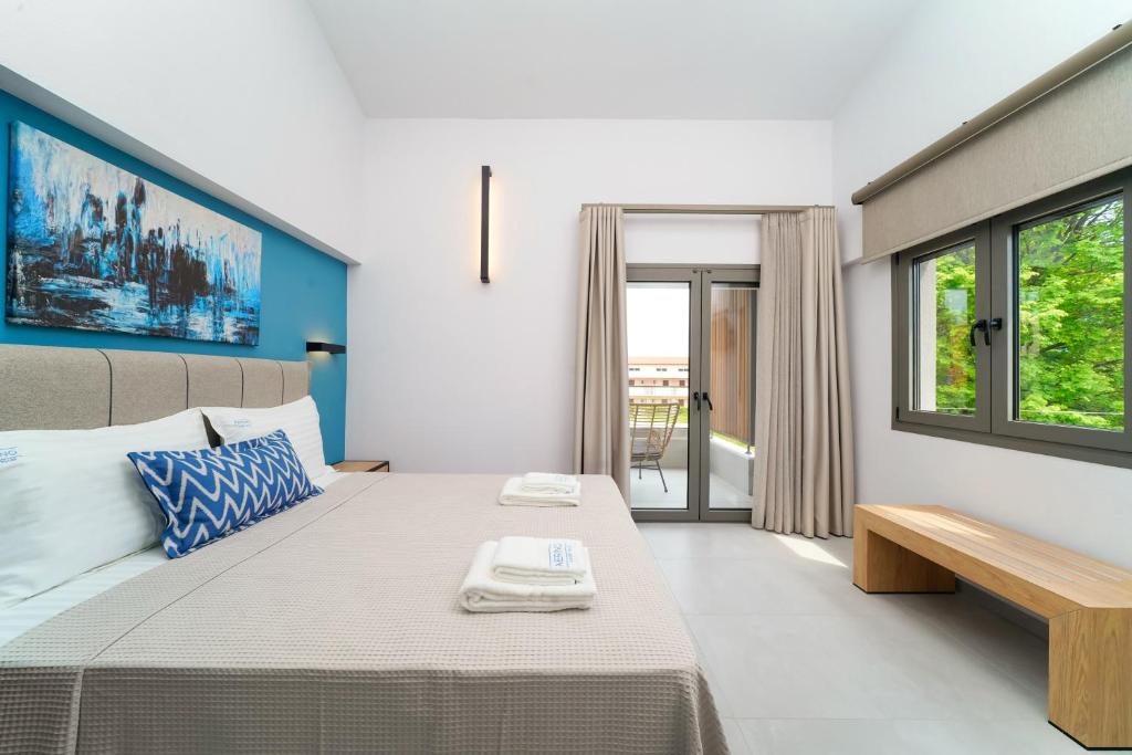 a bedroom with a large bed and a window at Aerino Luxury Villas in Chrysi Ammoudia