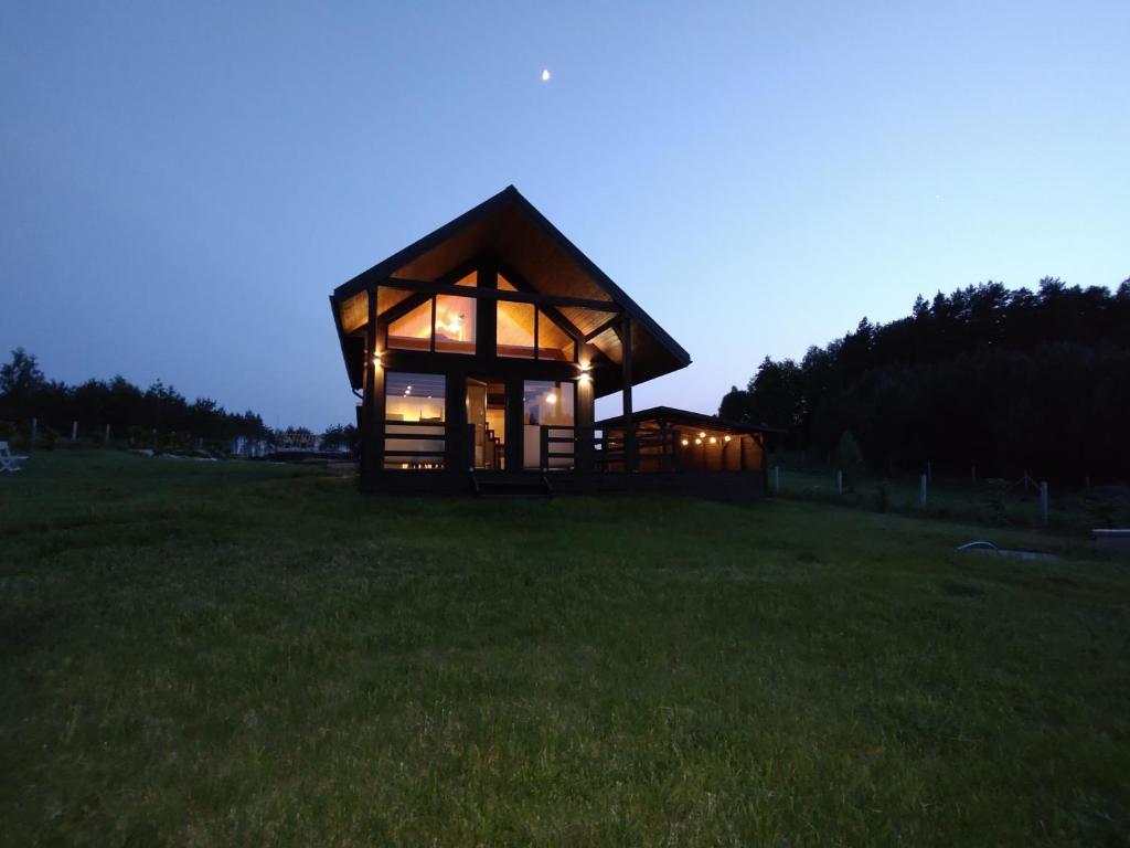 una cabaña en medio de un campo por la noche en Domek nad rzeką Rospuda 