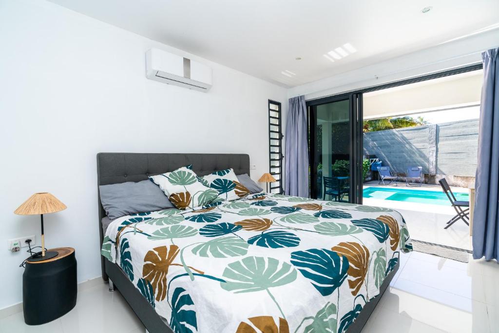 1 dormitorio con 1 cama con colcha colorida en Fare Fafapiti Mataiea wPool, en Otutara