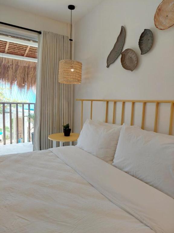 a bedroom with a bed and a table and a window at Sea Green Boutique Rooms in General Luna