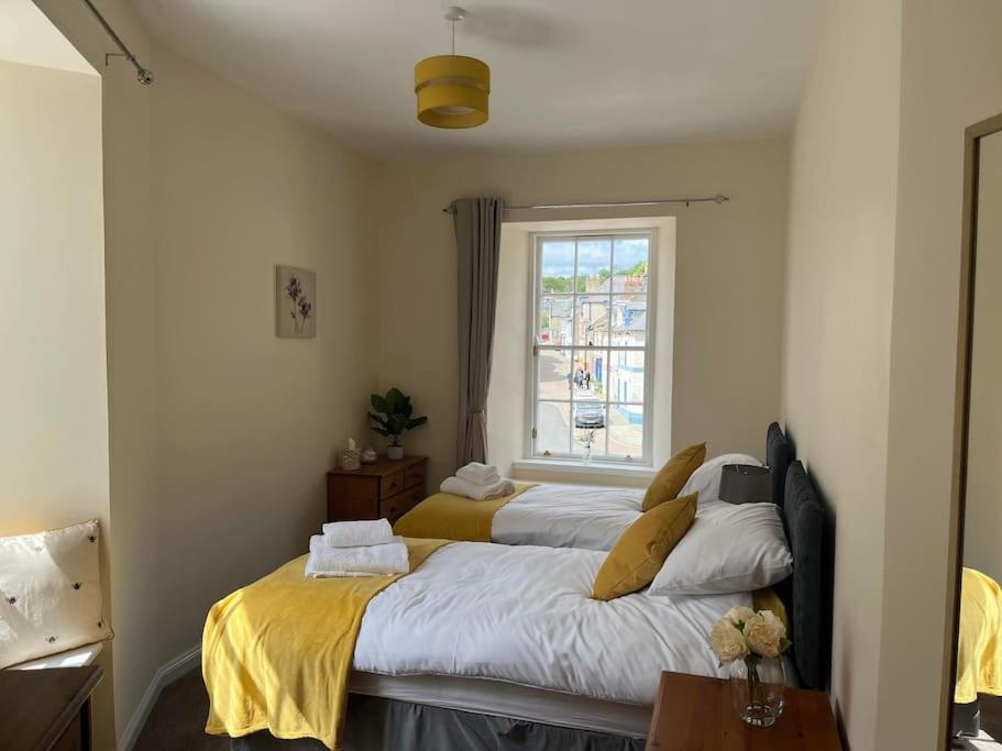 a bedroom with two beds and a window at 7A Murray Street in Duns