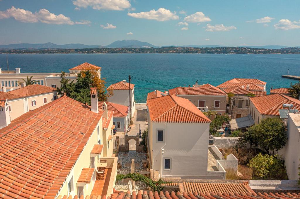 a view of a town with houses and the water at Kastro Hotel in Spetses