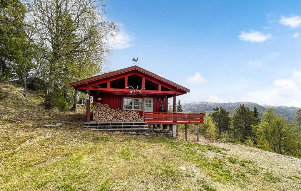 a small red cabin on a hill with trees at Amazing Home In Fvang With 3 Bedrooms in Tromsnes