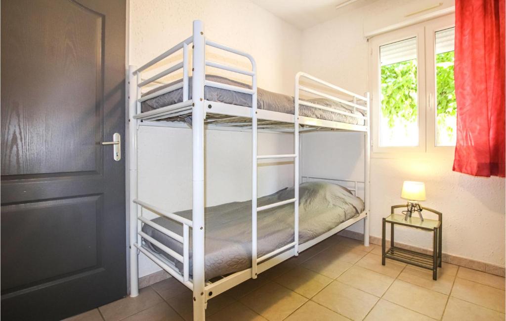 a room with two bunk beds and a window at Amazing Home In Grospierres With Outdoor Swimming Pool, Wifi And 2 Bedrooms in Grospierres