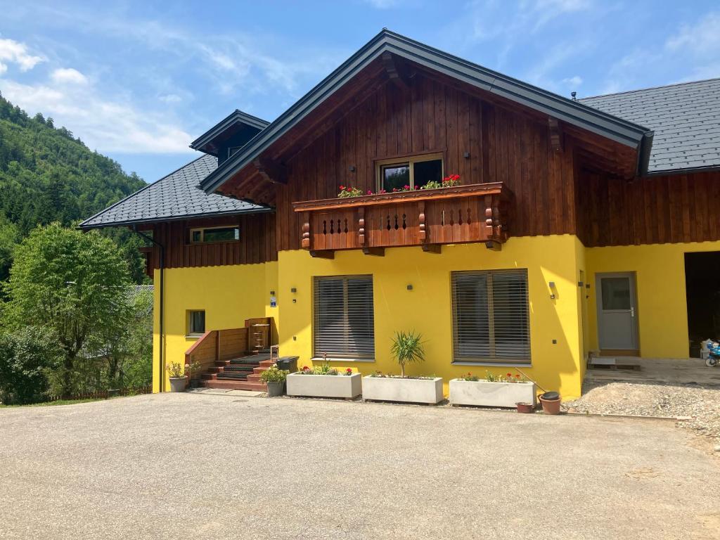 a yellow house with a balcony on top of it at Mahdgut 