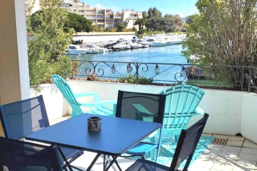uma mesa e cadeiras numa varanda com vista para um rio em Cannes Marina vue sur le port em Mandelieu-la-Napoule